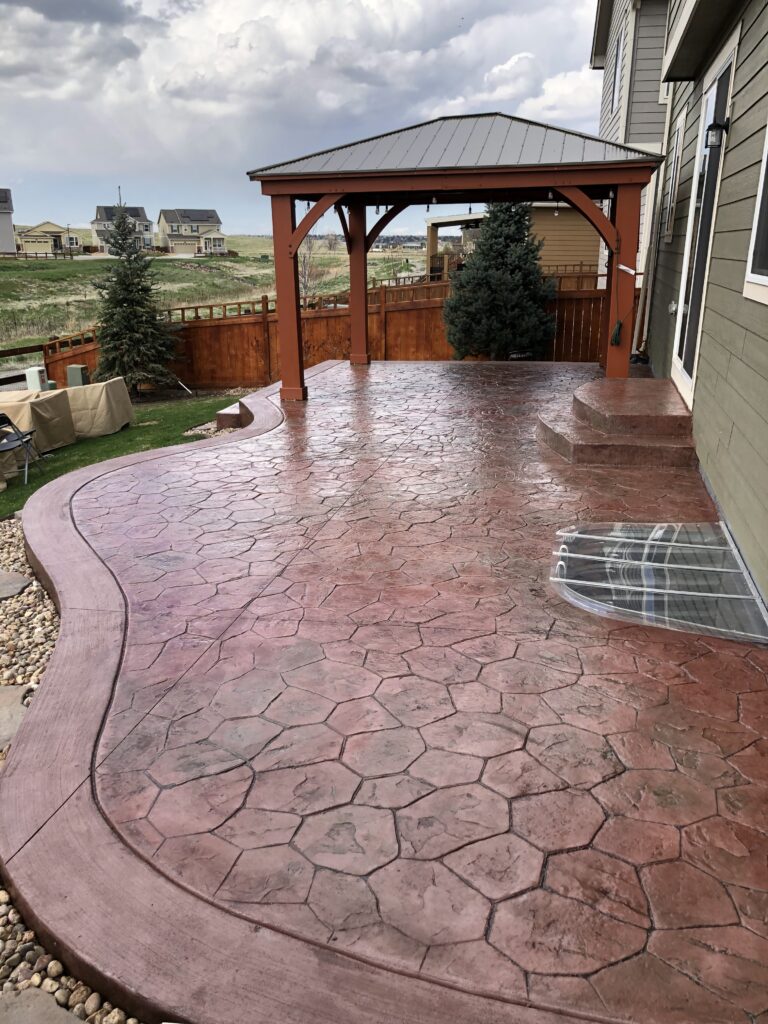 A colored stamped concrete patio and a house.