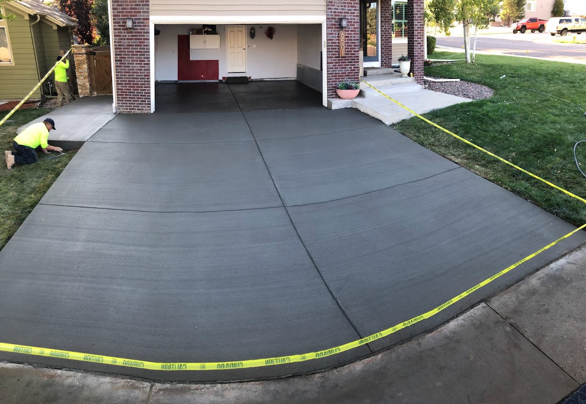 A concrete driveway with yellow tape