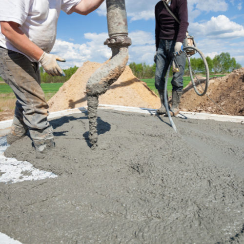 a few men pouring cement for a concrete foundation