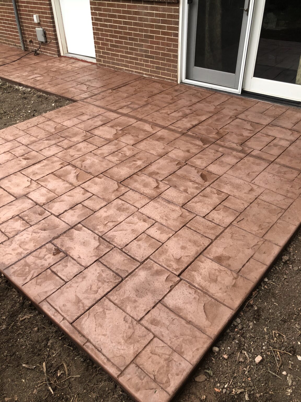 a patio with a brick wall and a door